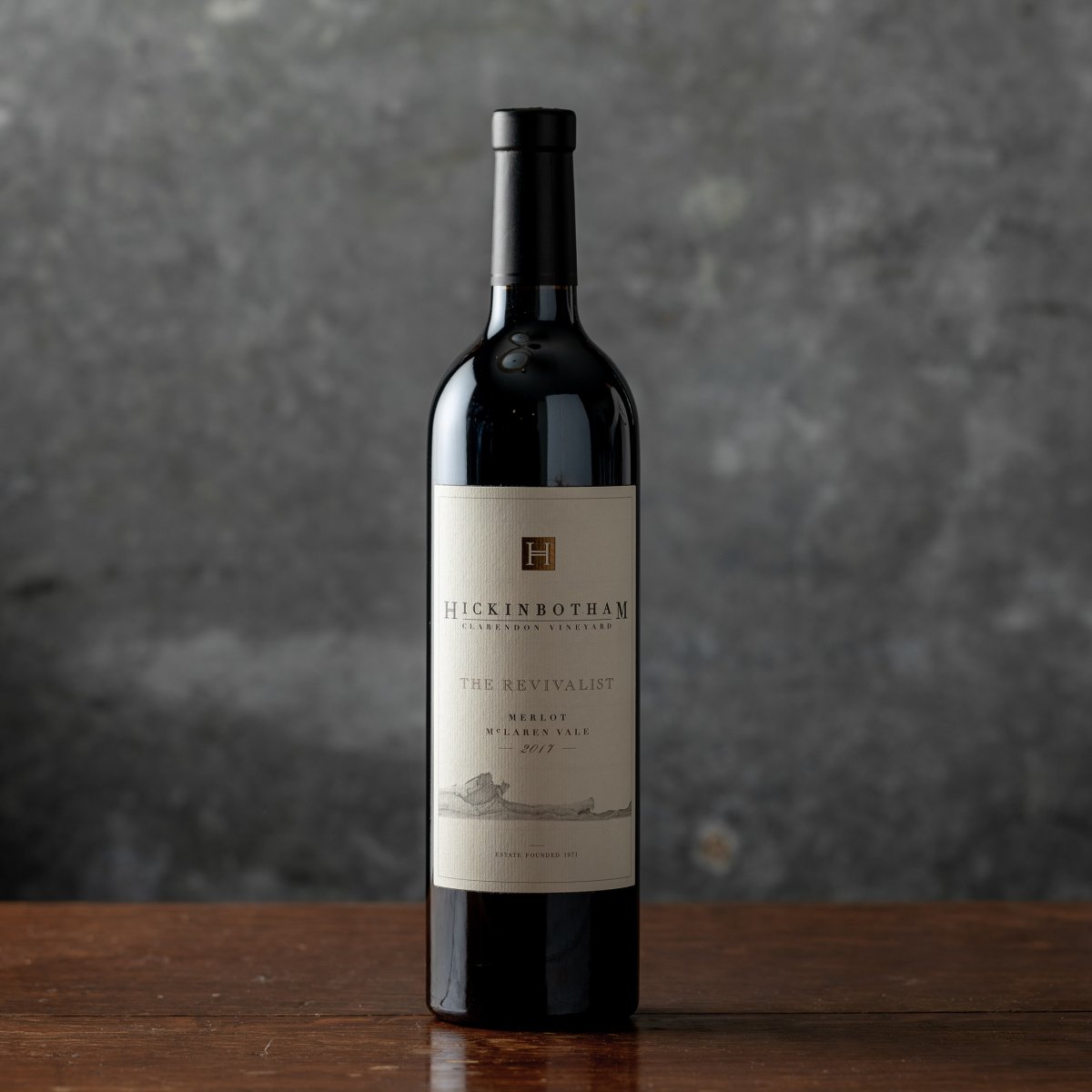 Wine bottle of The Revivialist Merlot against a gray backdrop